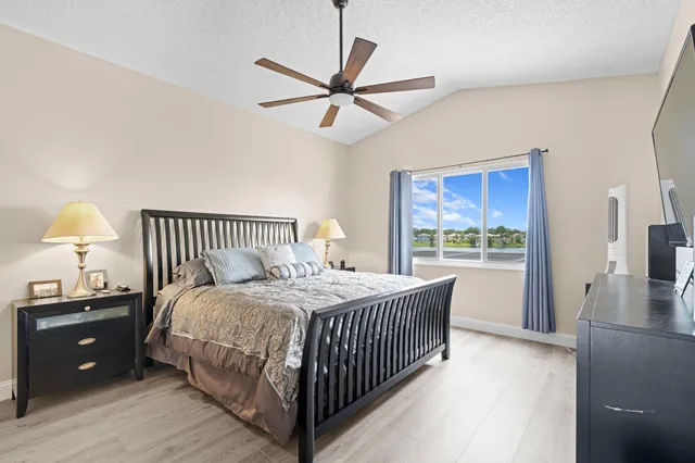 a bedroom with a bed a window and a chandelier