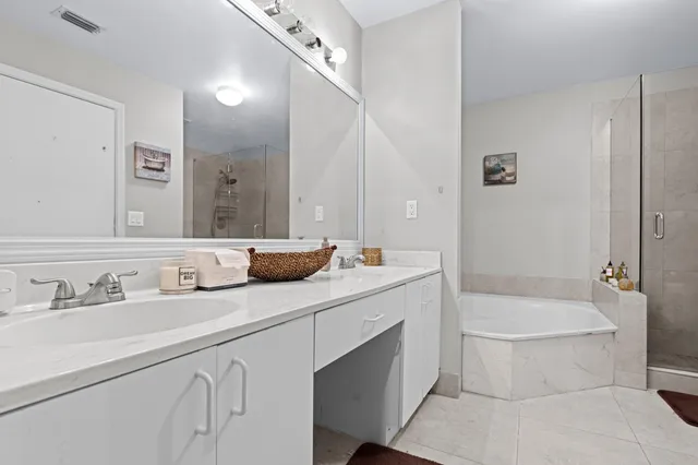a bathroom with a double vanity sink toilet mirror and bathtub