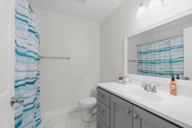 a bathroom with a sink a toilet and shower curtain