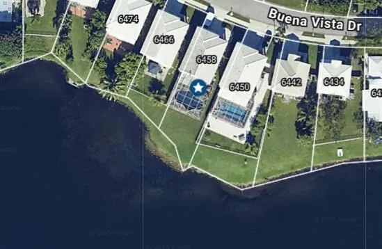 an aerial view of a residential houses with outdoor space and street view