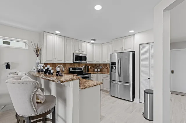 a kitchen with stainless steel appliances a refrigerator stove microwave and cabinets