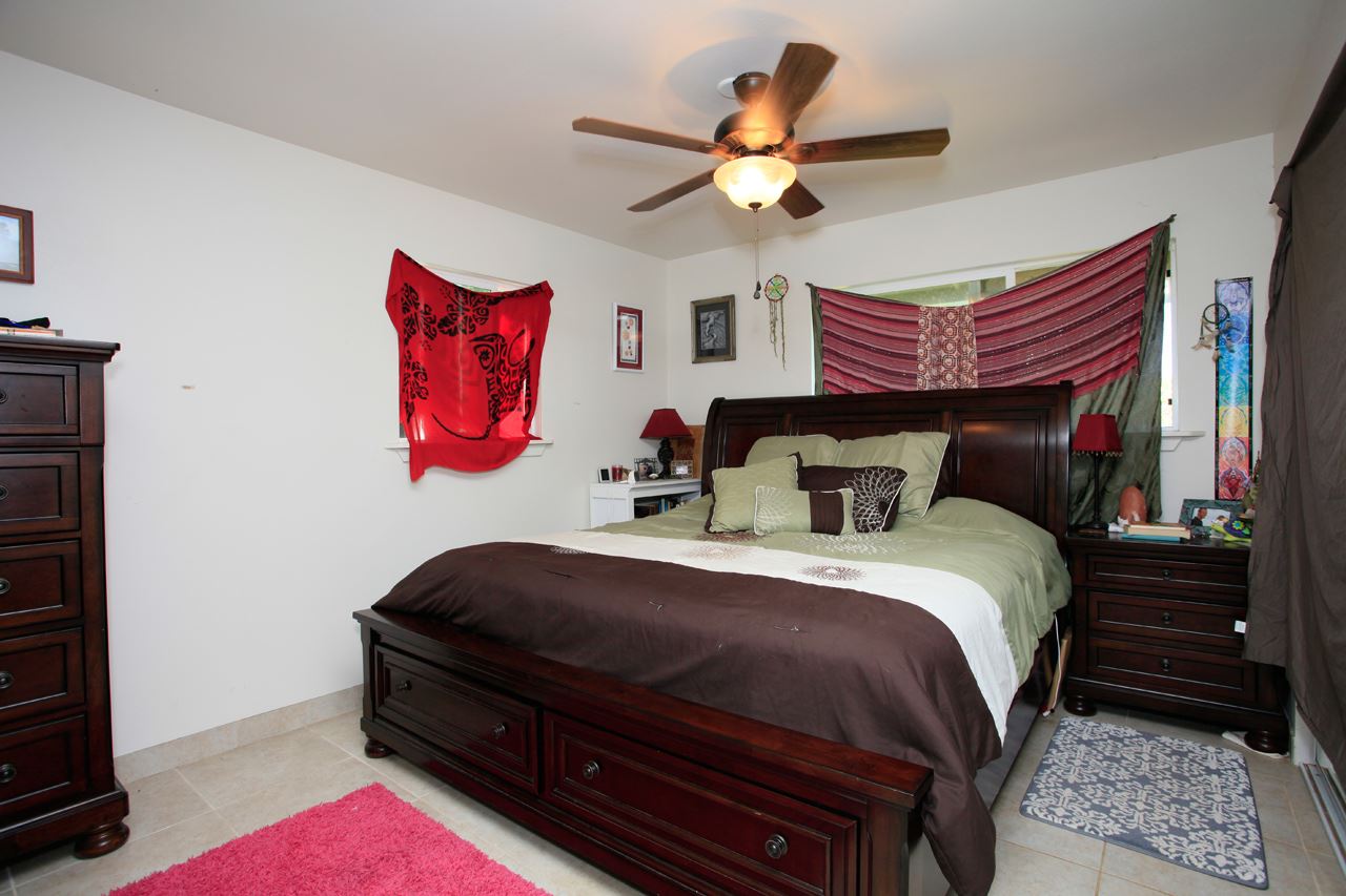 2811 Kokomo Road Haiku, HI 96708 - Photo 15 of 30 a bedroom with bed and a chandelier