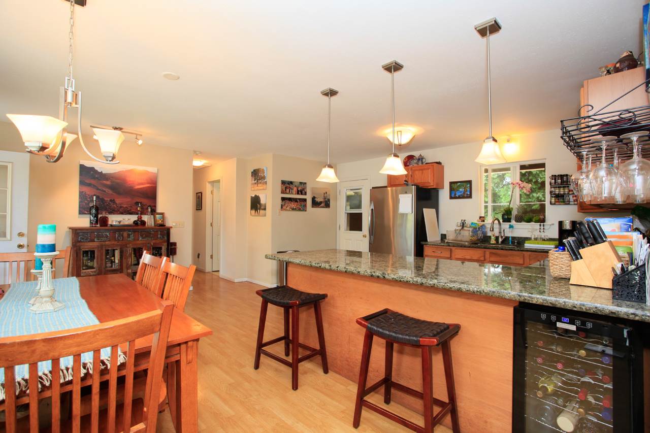 2811 Kokomo Road Haiku, HI 96708 - Photo 26 of 30 a kitchen with stainless steel appliances granite countertop sink stove and chairs