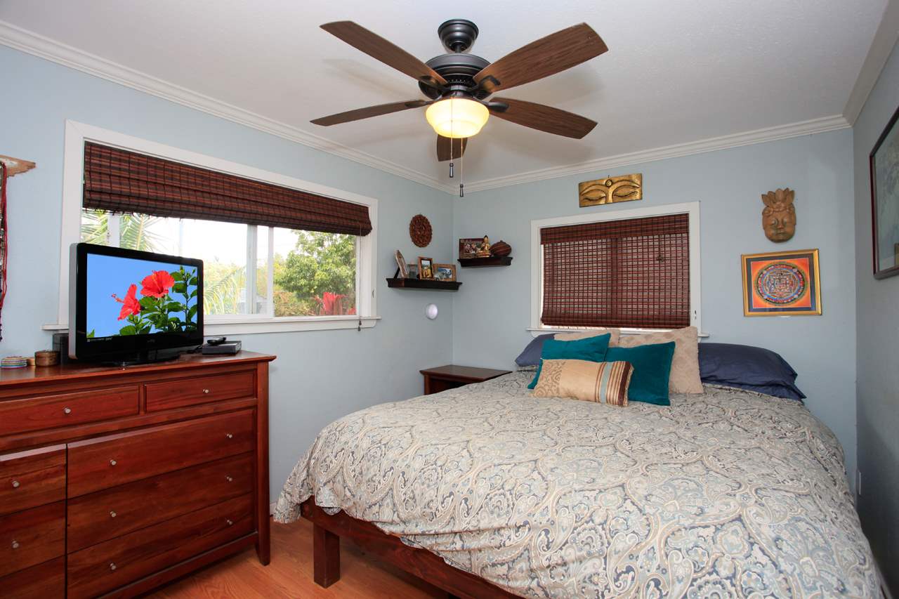 2811 Kokomo Road Haiku, HI 96708 - Photo 27 of 30 a bedroom with a bed and a flat screen tv