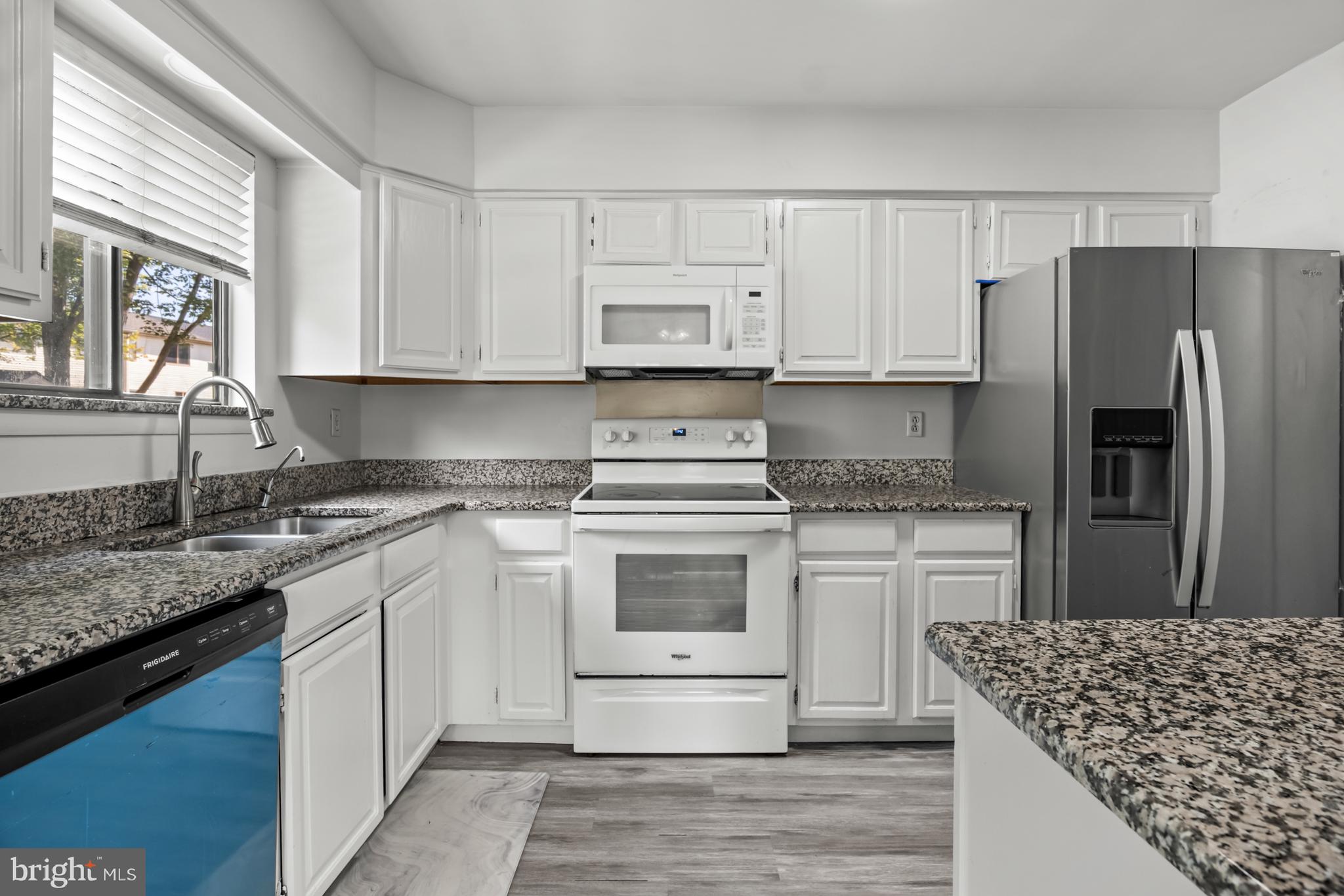 68 Liborio Lane New Castle, DE 19720 - Photo 11 of 38 a kitchen with stainless steel appliances granite countertop a stove a sink dishwasher a refrigerator and white cabinets