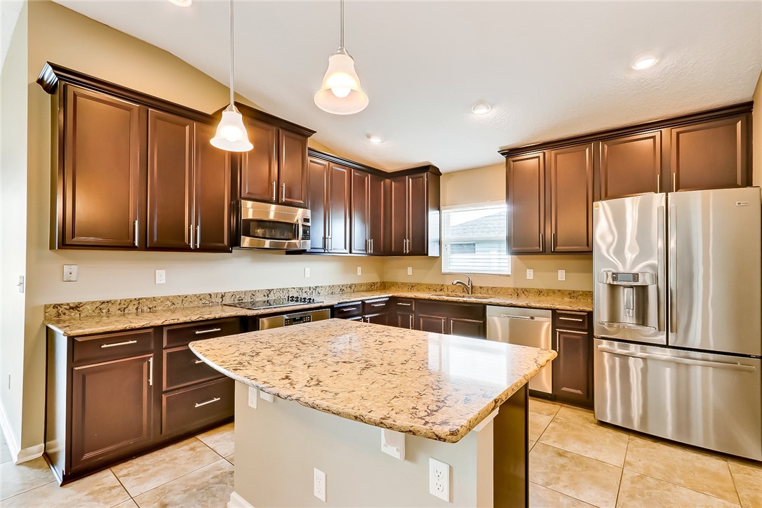 95227 Windflower Trail Fernandina Beach, FL 32034 - Photo 11 of 35 a kitchen with stainless steel appliances granite countertop a sink stove microwave and refrigerator