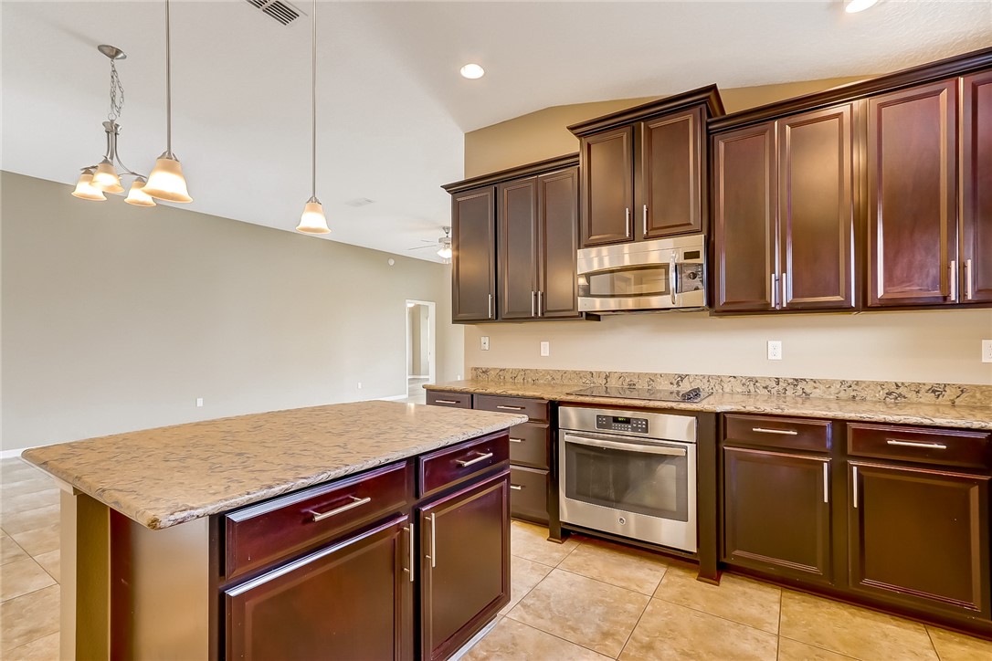 95227 Windflower Trail Fernandina Beach, FL 32034 - Photo 14 of 35 a kitchen with stainless steel appliances granite countertop a stove a sink dishwasher and a refrigerator