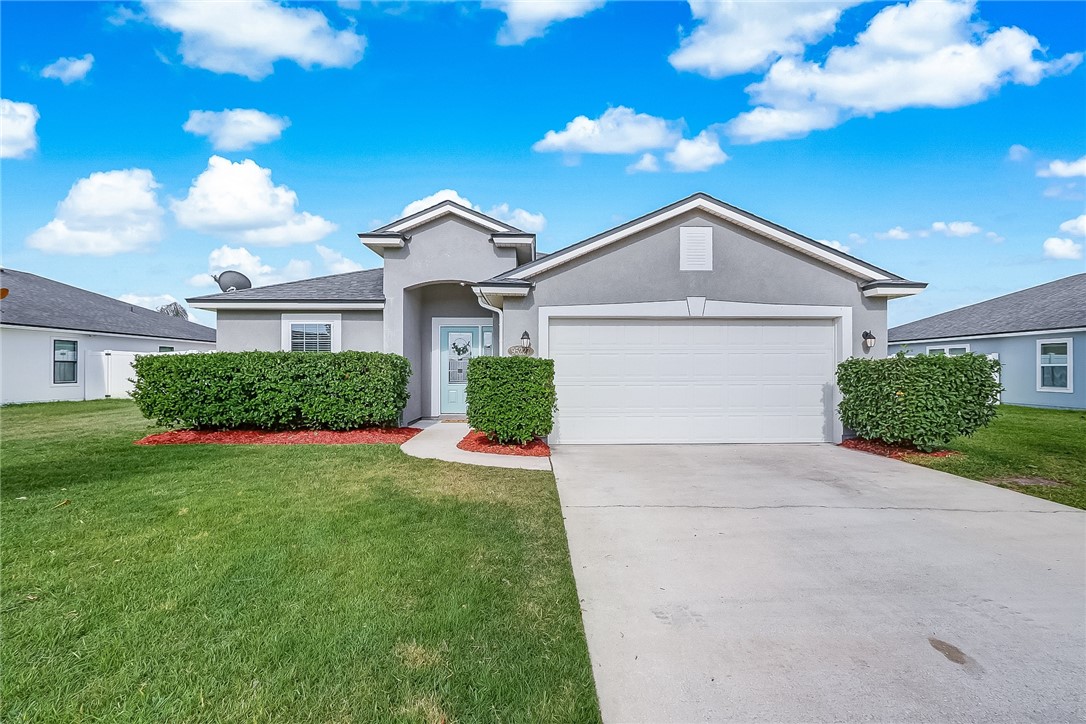 95227 Windflower Trail Fernandina Beach, FL 32034 - Photo 2 of 35 a front view of a house with a yard and garage