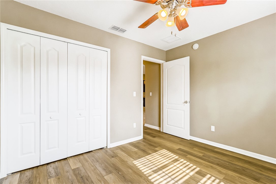 95227 Windflower Trail Fernandina Beach, FL 32034 - Photo 26 of 35 a view of a room with wooden floor and a chandelier fan
