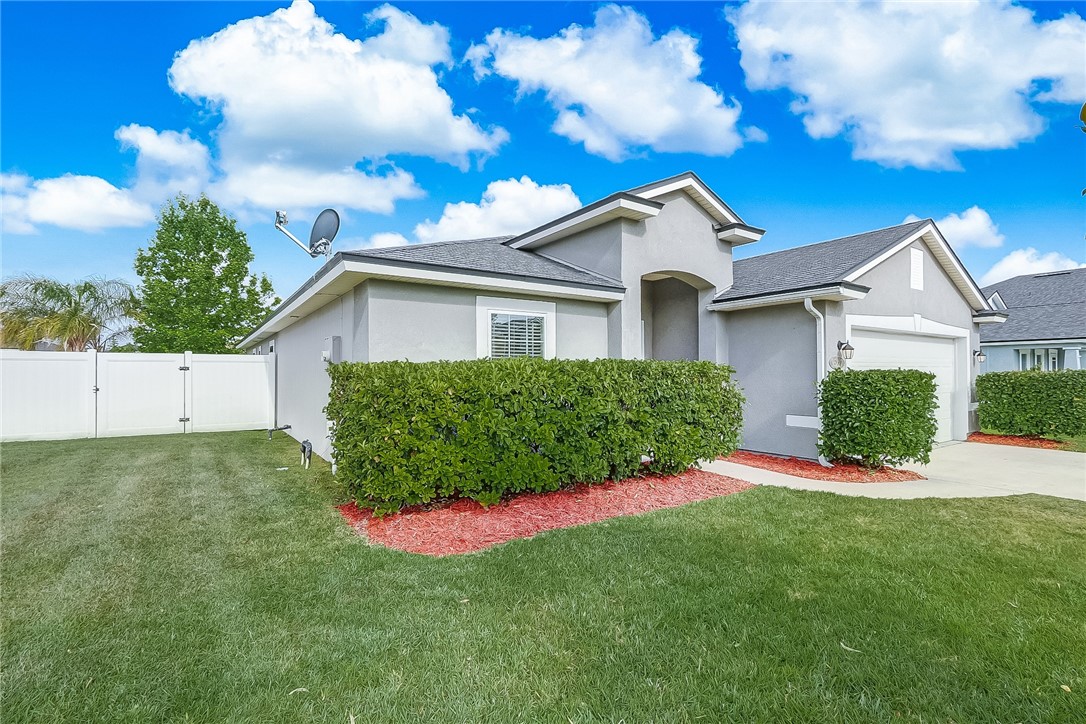 95227 Windflower Trail Fernandina Beach, FL 32034 - Photo 3 of 35 a view of a house with a yard and potted plants