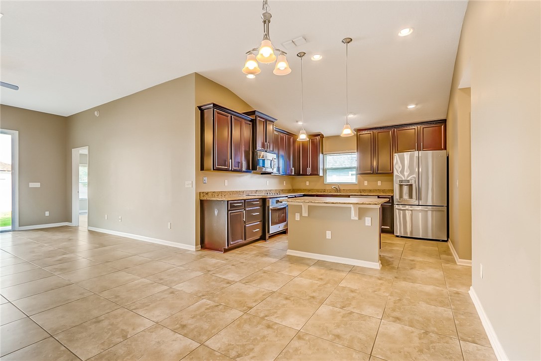 95227 Windflower Trail Fernandina Beach, FL 32034 - Photo 9 of 35 a large kitchen with a refrigerator and a stove top oven