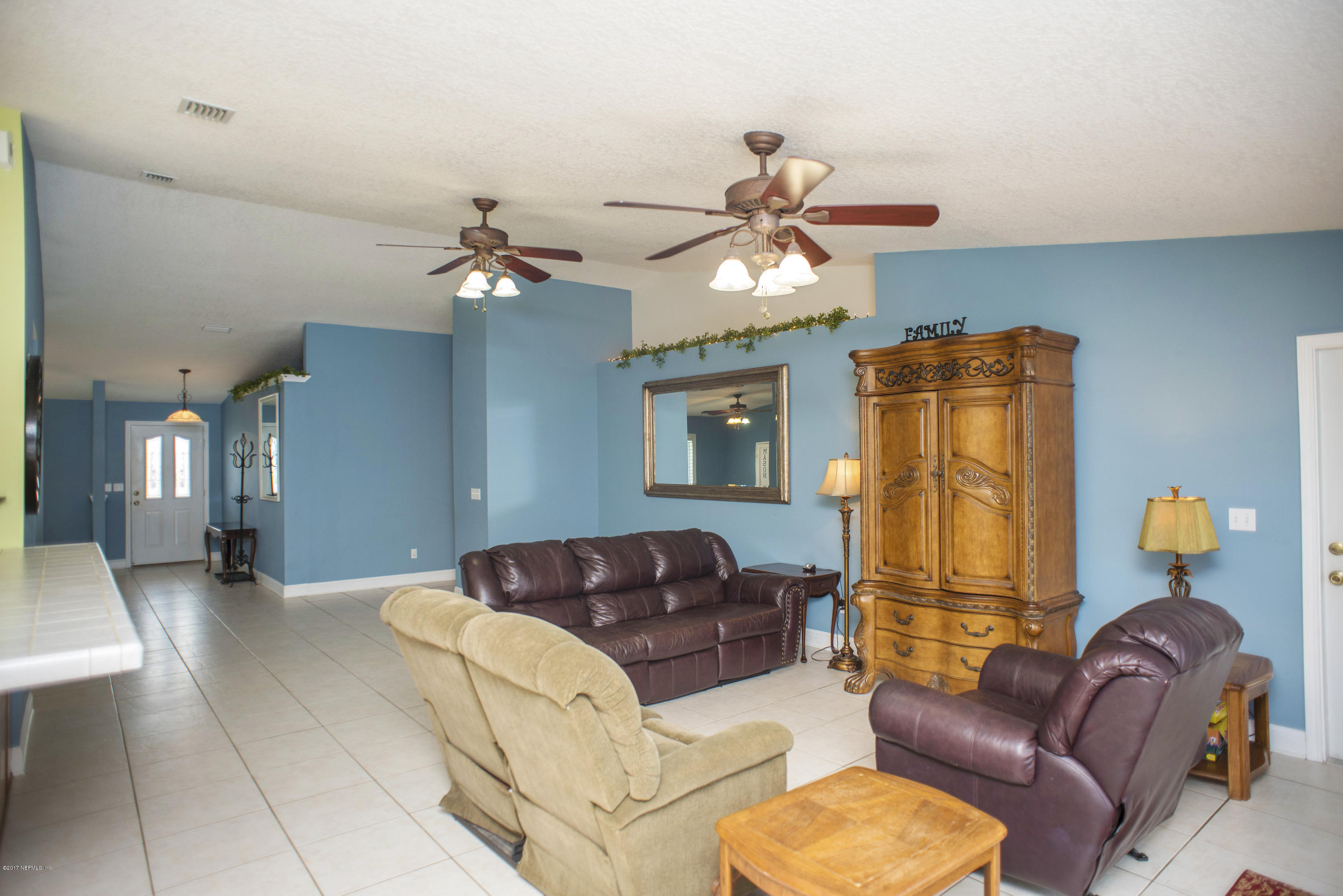 244 Barco Road St. Augustine, FL 32080 - Photo 6 of 31 a living room with furniture a chandelier fan and a window