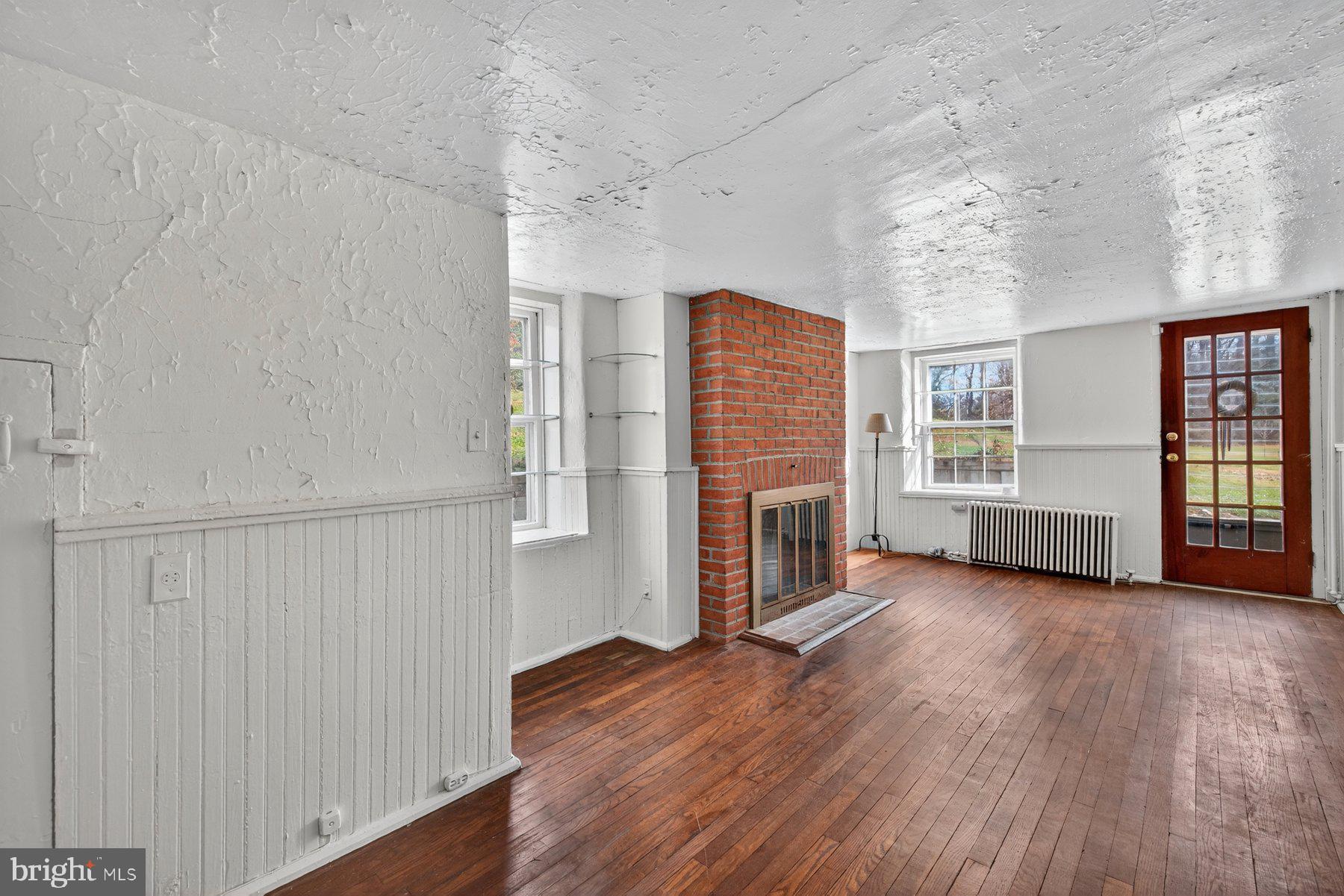 16306 Trenton Road Upperco, MD 21155 - Photo 8 of 55 wooden floor in an empty room with a fireplace