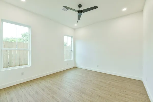 an empty room with a window and wooden floor