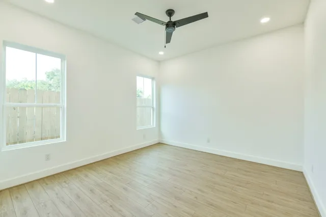 an empty room with a window and wooden floor