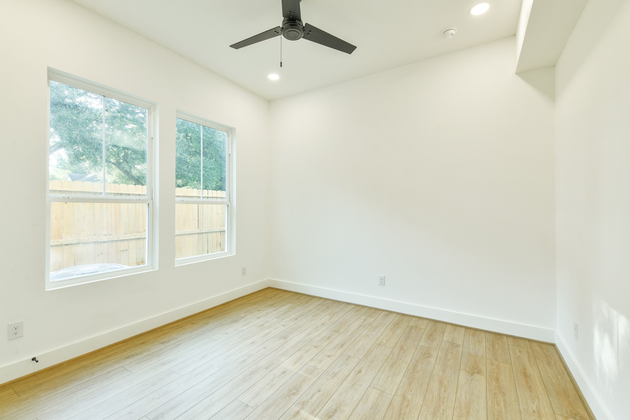 162 Wallace Street, Unit A Houston, TX 77022 - Photo 27 of 29 an empty room with wooden floor fan and windows