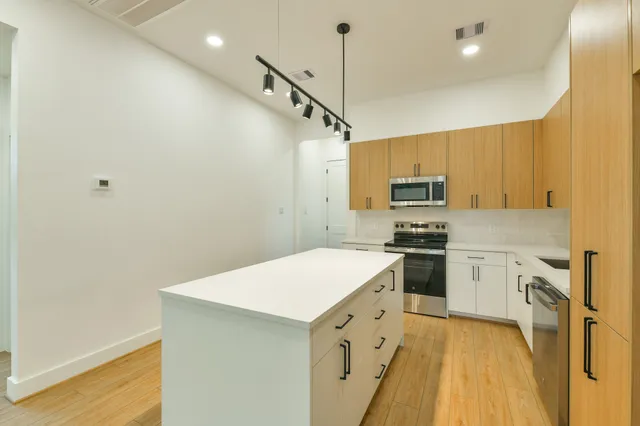 a kitchen with granite countertop a sink stainless steel appliances and white cabinets