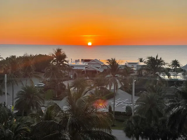 an aerial view of a city with lots of residential buildings and mountain view in back