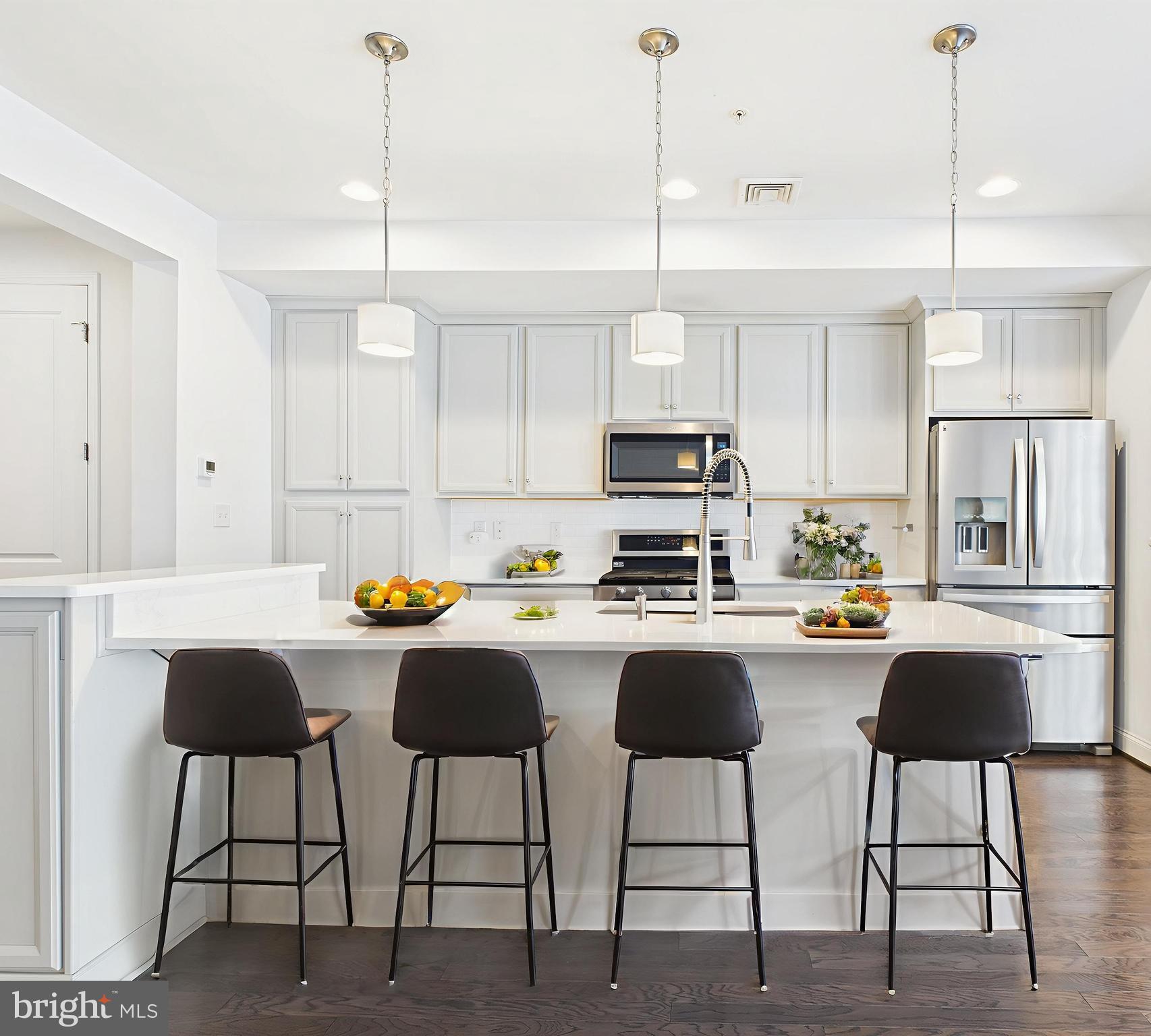 a kitchen with stainless steel appliances granite countertop a stove a sink a refrigerator a center island a stove and a cabinets