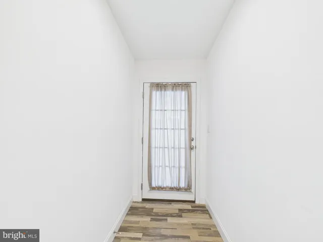 a view of a livingroom with wooden floor and a window