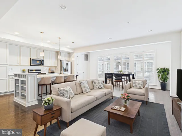 a living room with furniture white walls and kitchen view