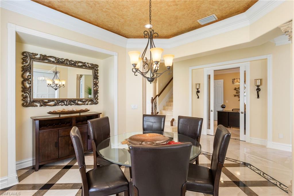 2135 Par Drive Naples, FL 34120 - Photo 3 of 46 a dining room with furniture a chandelier and wooden floor