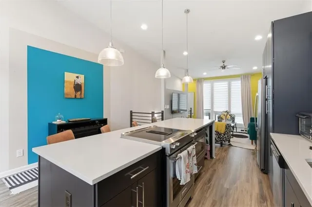 a kitchen with a stove a refrigerator a sink and chairs