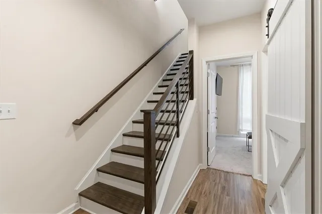 a view of staircase with wooden floor and white walls