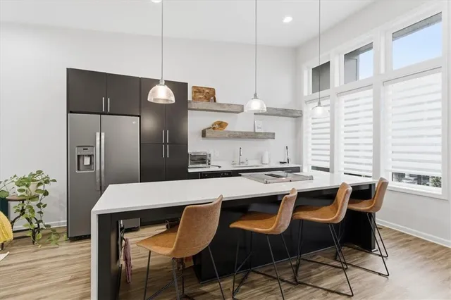 a kitchen with a table chairs refrigerator and wooden floor