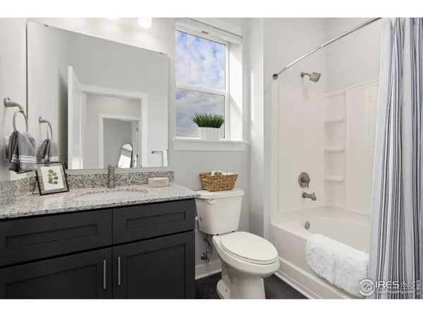 a bathroom with a granite countertop sink toilet a large mirror a bathtub and shower