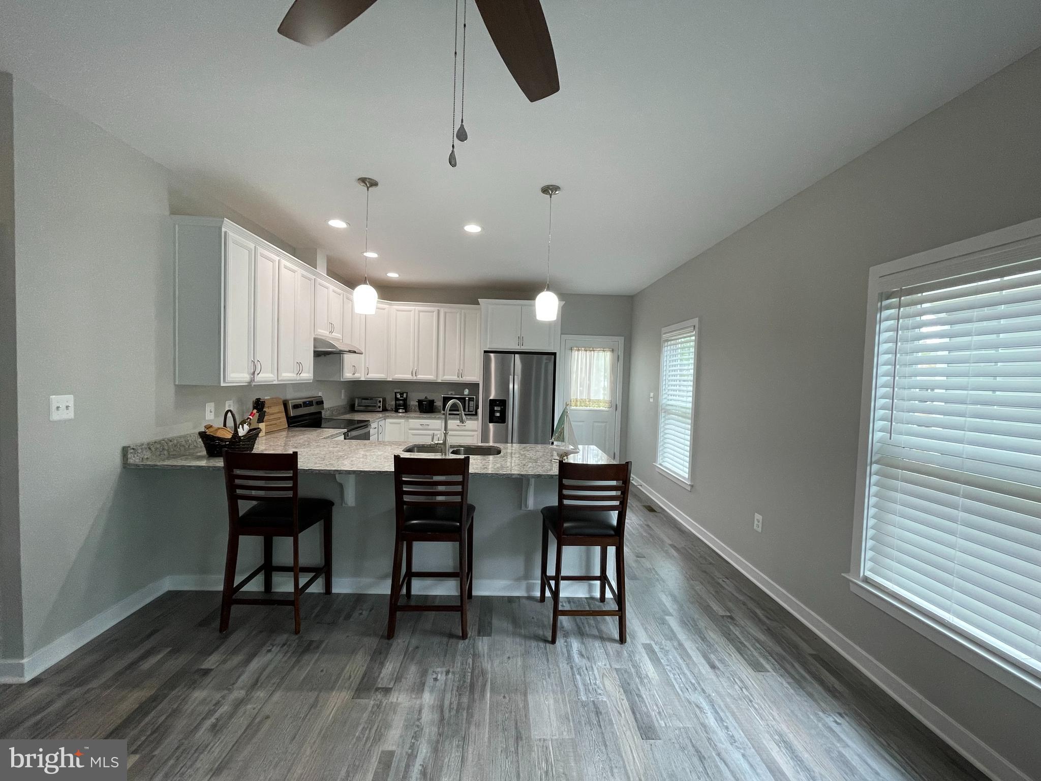 325 2nd Street Colonial Beach, VA 22443 - Photo 4 of 14 a kitchen with a dining table chairs and white cabinets