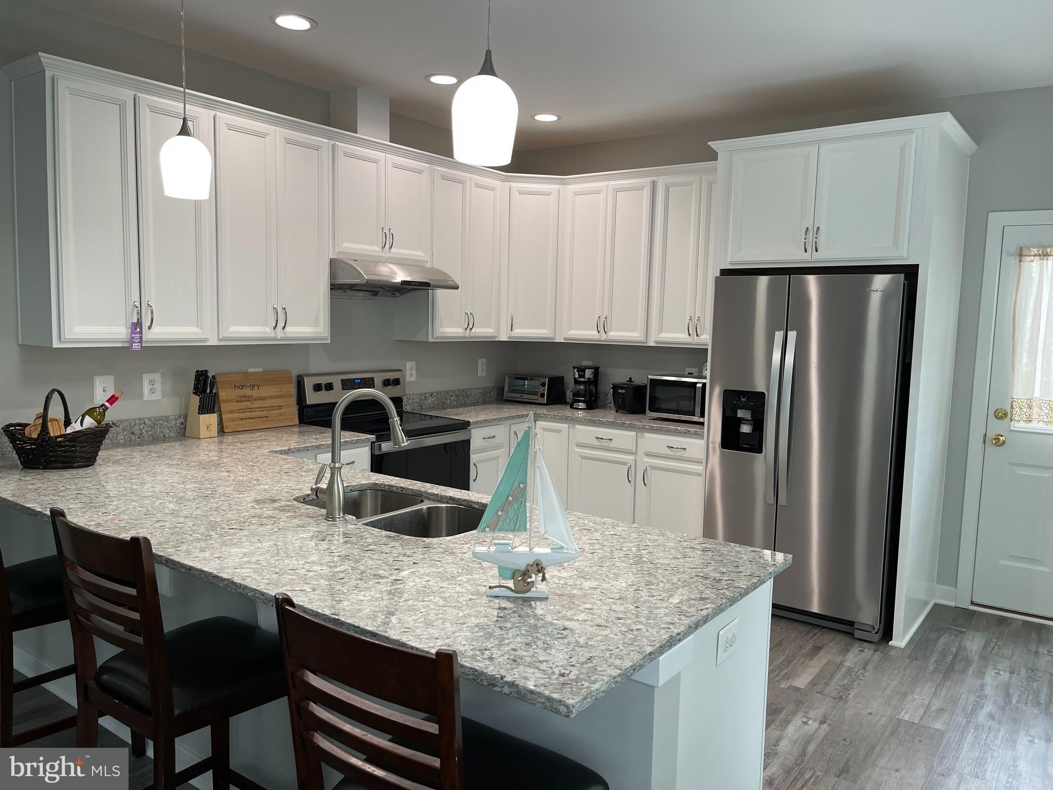325 2nd Street Colonial Beach, VA 22443 - Photo 5 of 14 a kitchen with stainless steel appliances granite countertop a sink refrigerator and cabinets
