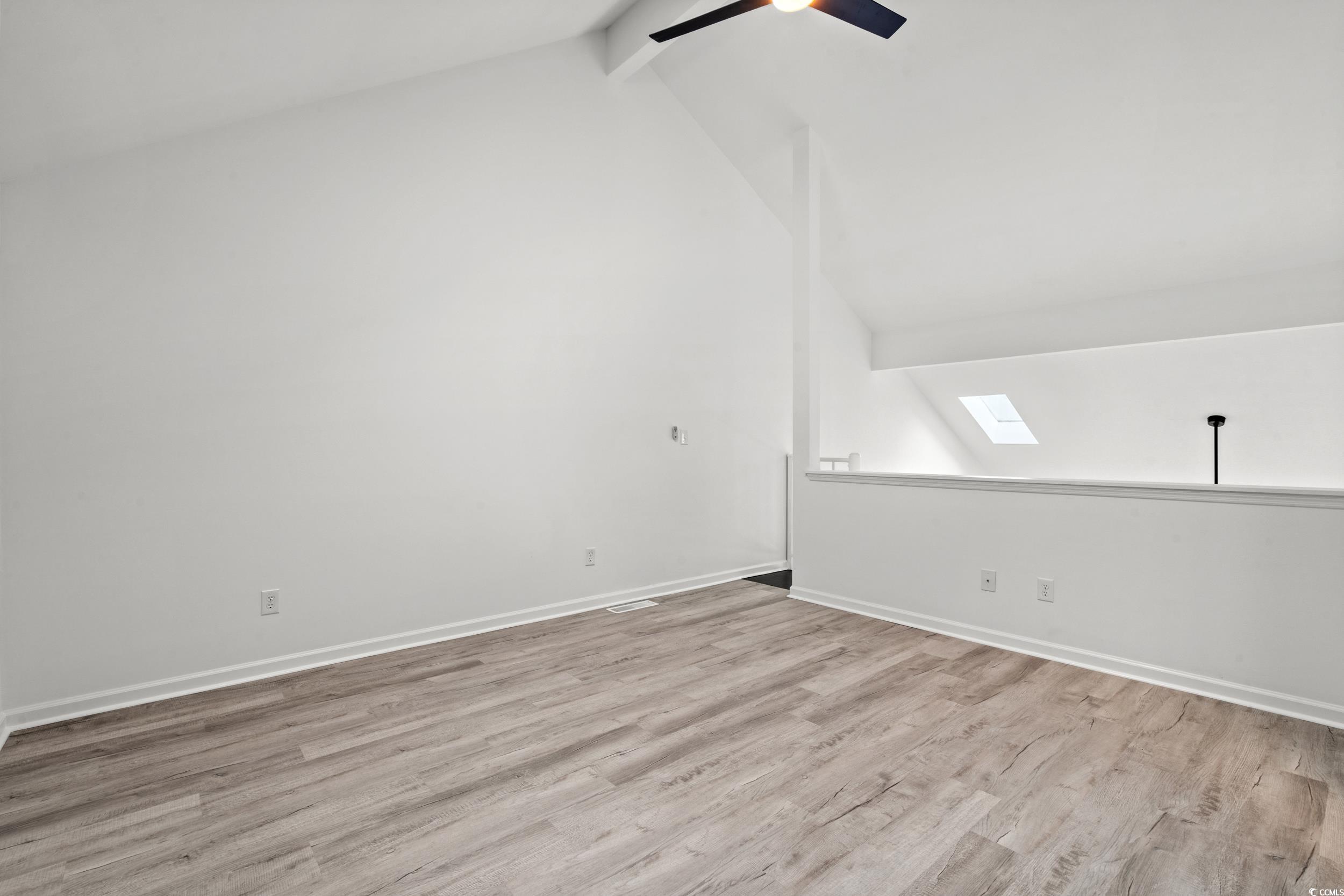 1890 Colony Drive, Unit 17L Surfside Beach, SC 29575 - Photo 18 of 38 Additional living space featuring beam ceiling, a ceiling fan, light wood finished floors, high vaulted ceiling, and a skylight