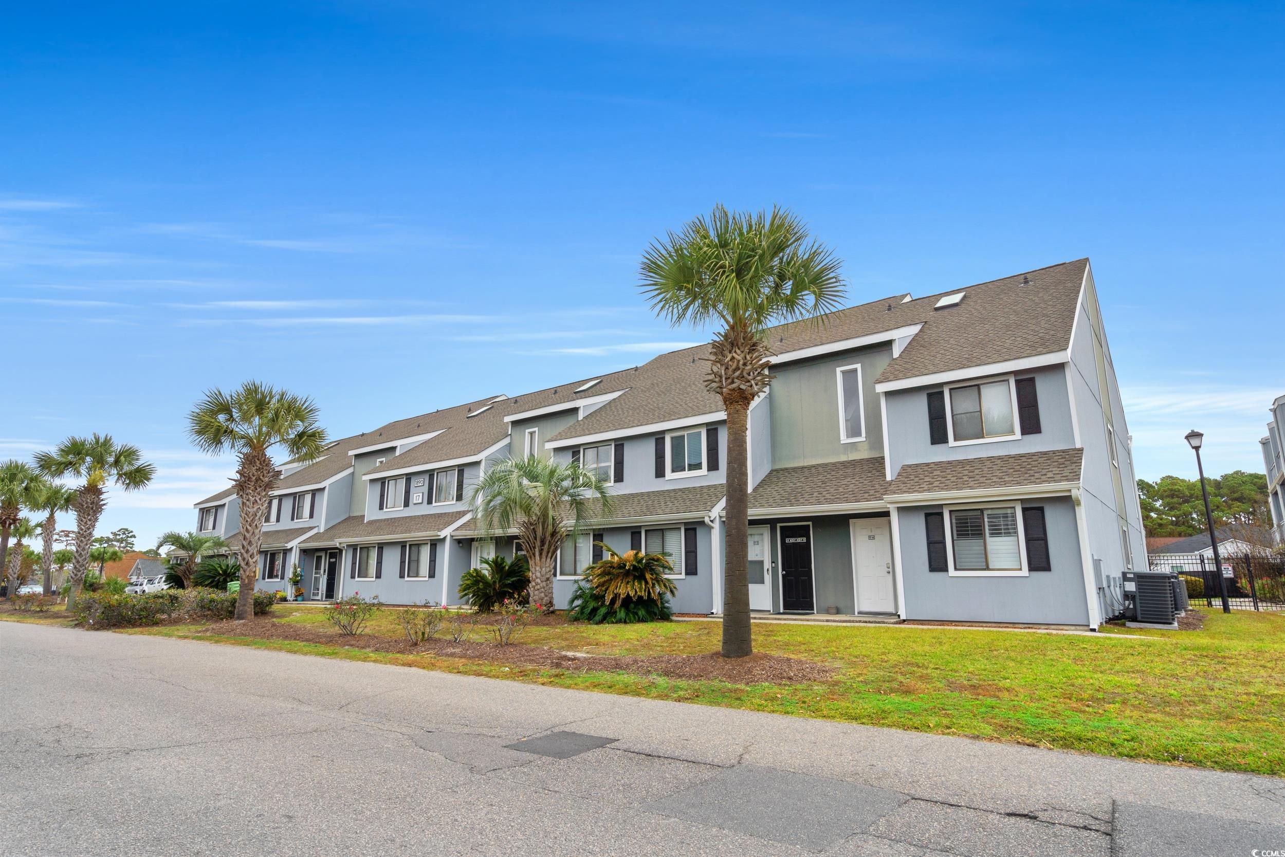 1890 Colony Drive, Unit 17L Surfside Beach, SC 29575 - Photo 2 of 38 Traditional-style house with roof with shingles and a front yard