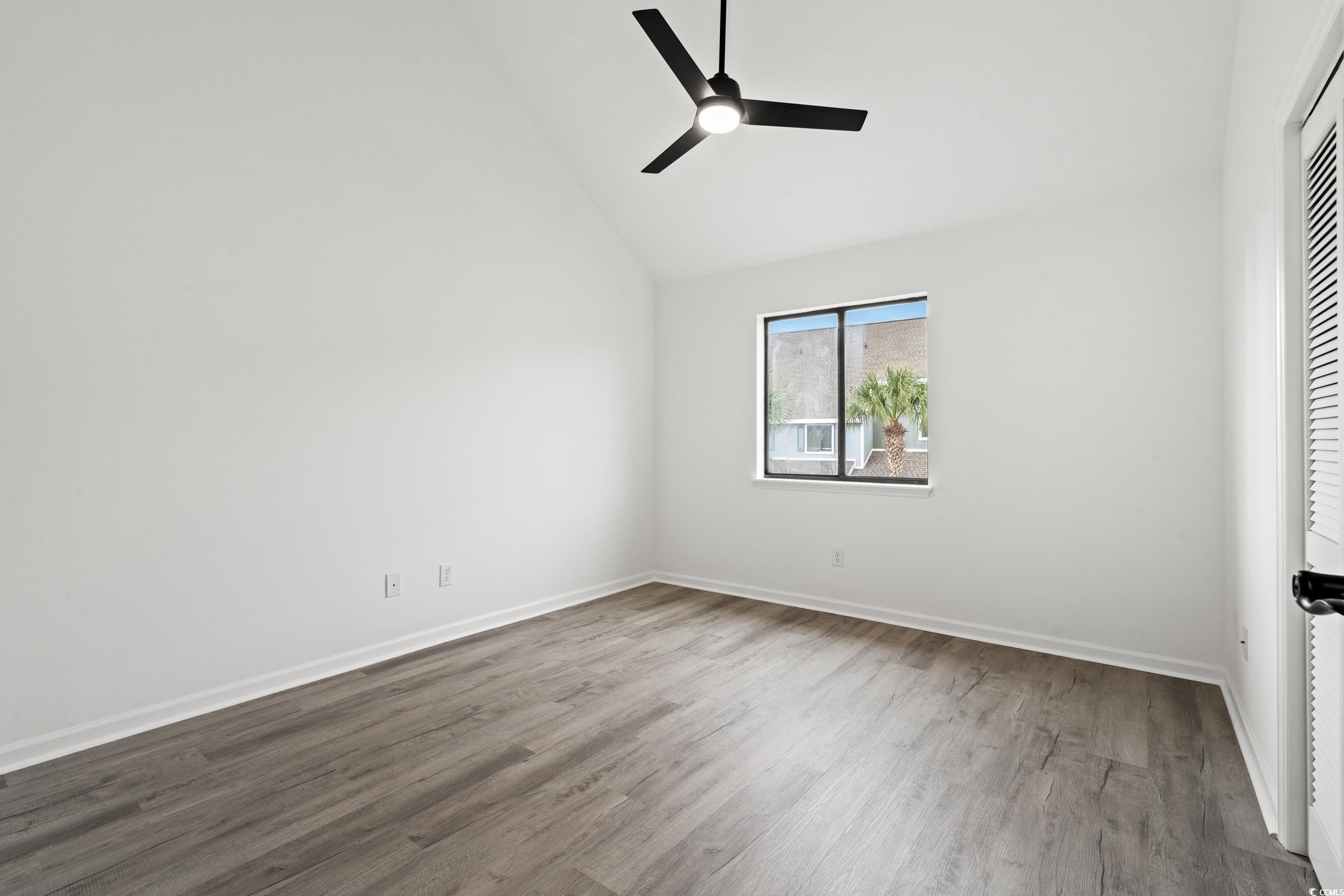 1890 Colony Drive, Unit 17L Surfside Beach, SC 29575 - Photo 23 of 38 Empty room featuring wood finished floors, high vaulted ceiling, and a ceiling fan
