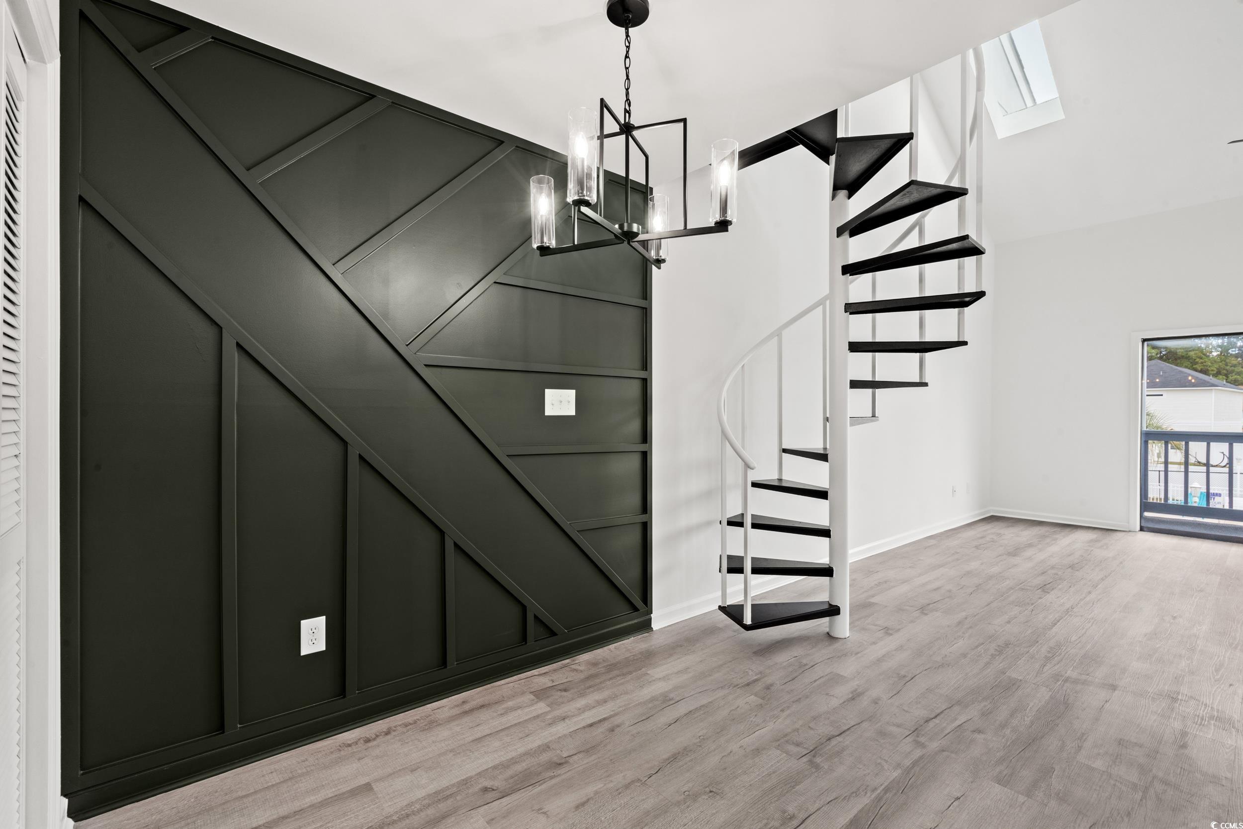 1890 Colony Drive, Unit 17L Surfside Beach, SC 29575 - Photo 6 of 38 Foyer with a decorative wall, stairs, light wood-type flooring, a chandelier, and a high ceiling