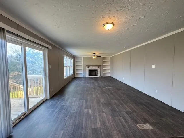 wooden floor fireplace and windows in an empty room
