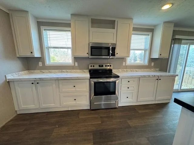 a kitchen with stainless steel appliances granite countertop a stove and wooden floor