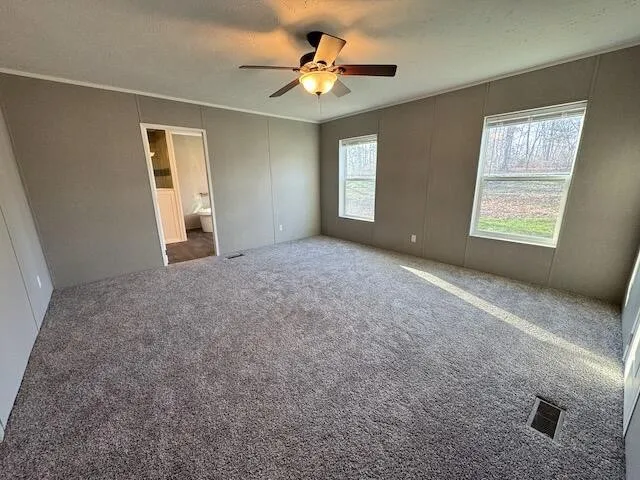 a living room with stainless steel appliances a wooden floor a sink and a window