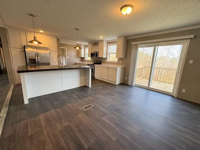 a kitchen with stainless steel appliances granite countertop a refrigerator a stove and a sink