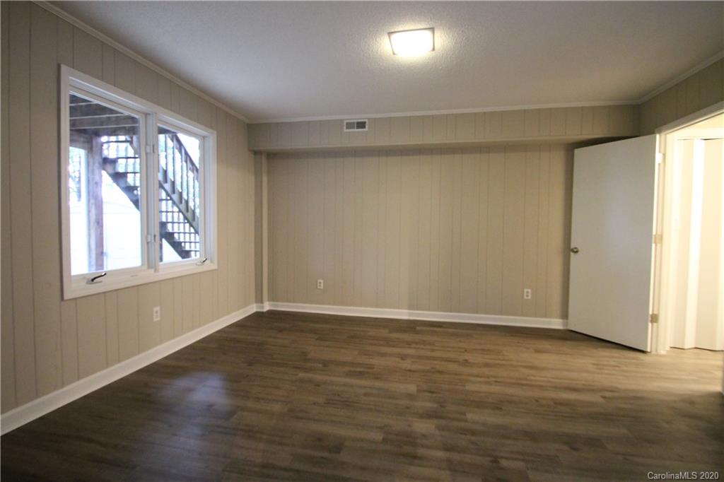 28006 Marina Drive, Unit 6 Tega Cay, SC 29708 - Photo 14 of 32 a view of an empty room with wooden floor and a window