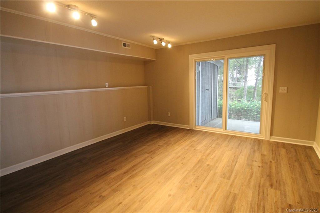 28006 Marina Drive, Unit 6 Tega Cay, SC 29708 - Photo 22 of 32 a view of an empty room with wooden floor and a window