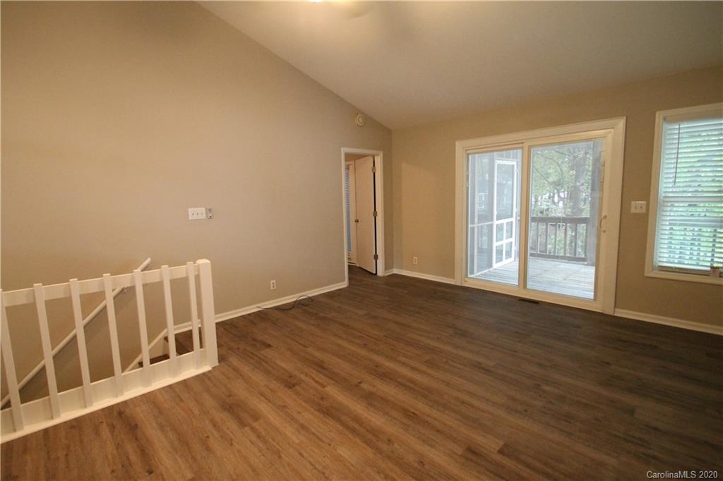 28006 Marina Drive, Unit 6 Tega Cay, SC 29708 - Photo 8 of 32 a view of an empty room with wooden floor and windows