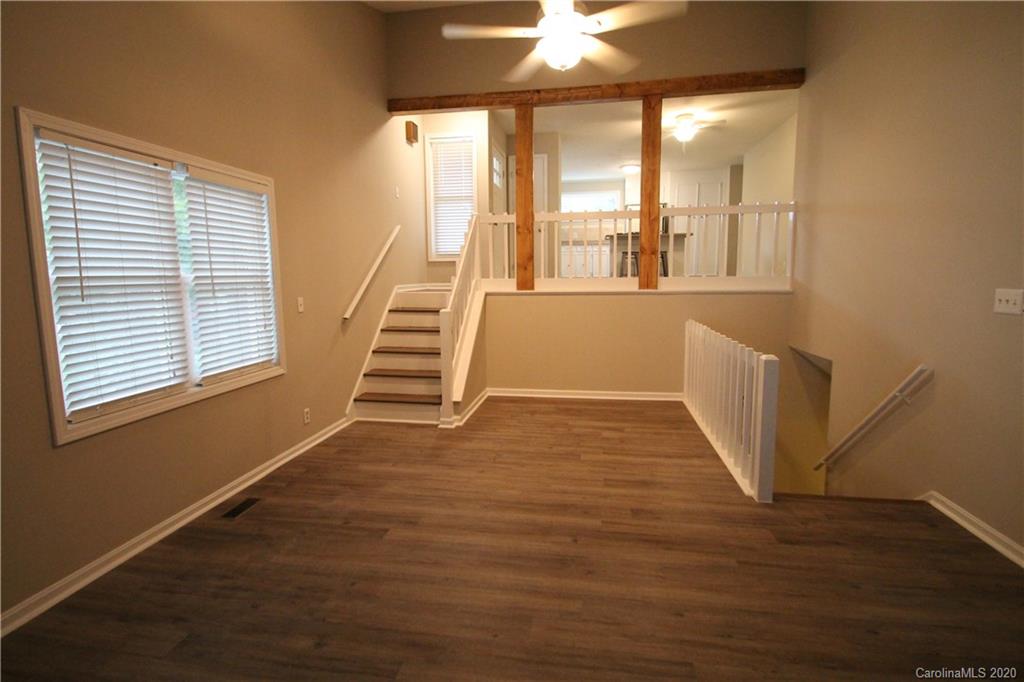 28006 Marina Drive, Unit 6 Tega Cay, SC 29708 - Photo 10 of 32 a view of an empty room with wooden floor and a window