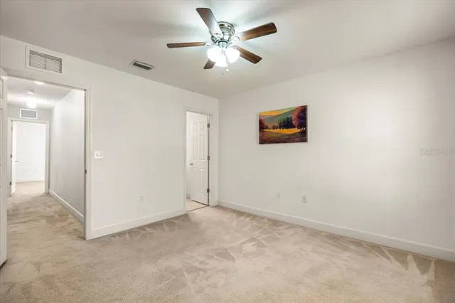 an empty room with closet and a ceiling fan
