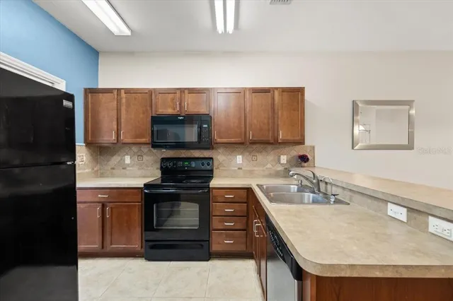 a kitchen with kitchen island granite countertop a sink stove and refrigerator