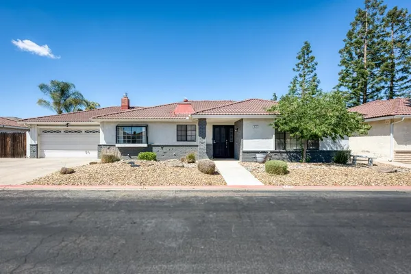a view of a house with a tree in front