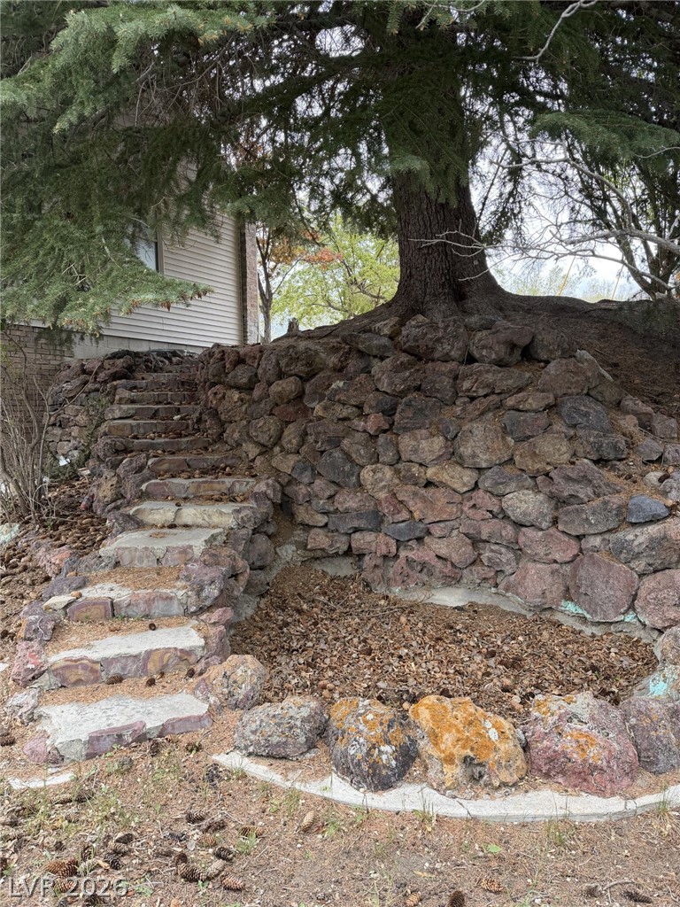 1 Carson Court Ely, NV 89301 - Photo 19 of 20 This outdoor space features stone stairs leading up a rock-faced incline to a dwelling.
