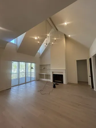 an empty room with windows and fireplace