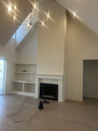 an empty room with windows and fireplace